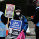 A Julian Assange supporter is spoken to by police officers outside the Old Bailey in London, Monday, Jan. 4, 2021.